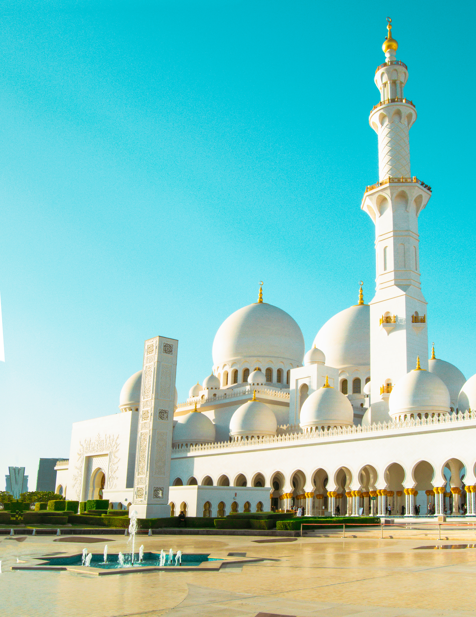Old mosque with golden cupolas near fountain on square